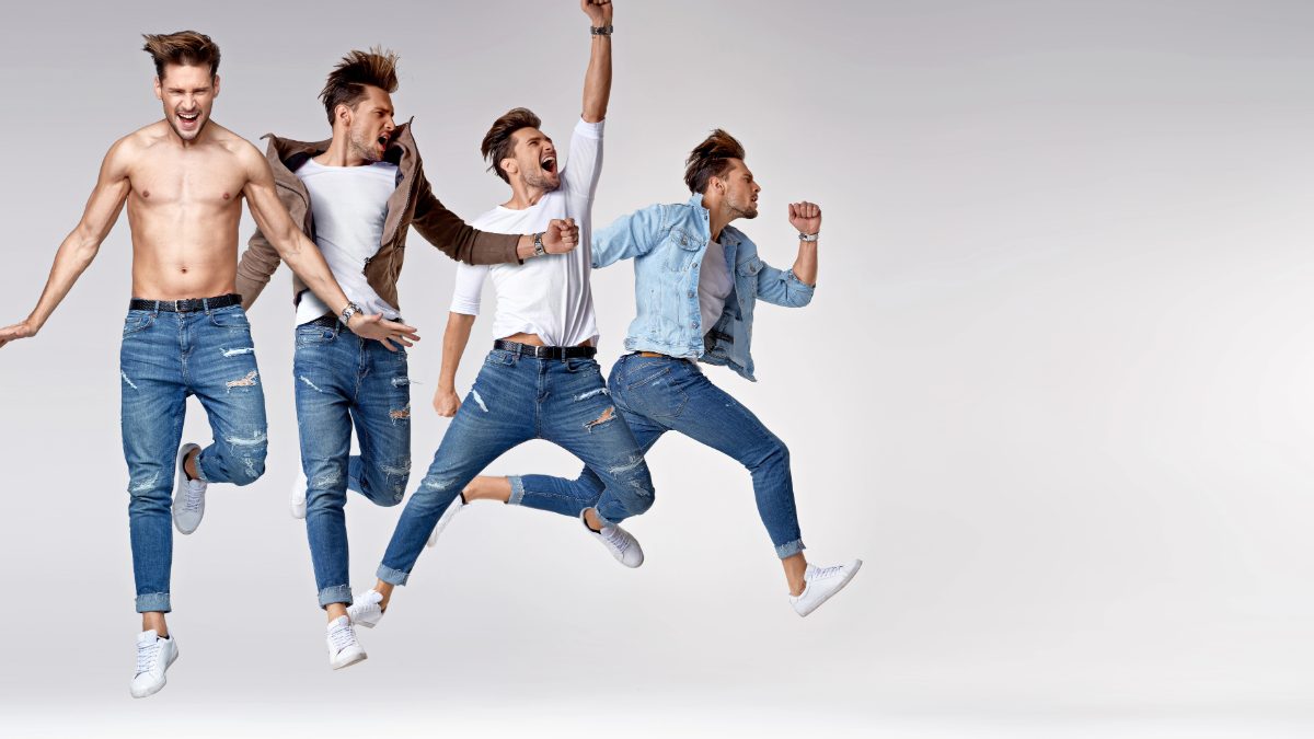 Group of male creators in denim celebrating together